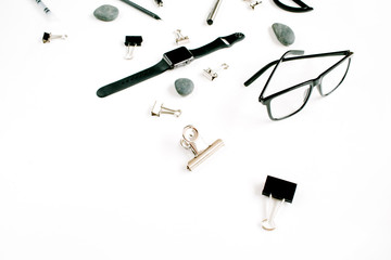 White office table desk with supplies. Glasses, watch, clips and stones on white background. Flat lay, top view.