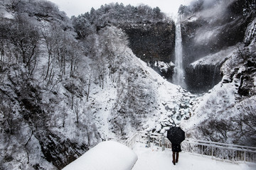 Person enjoying the view of the snowy Kegon falls - Nikko, Japan