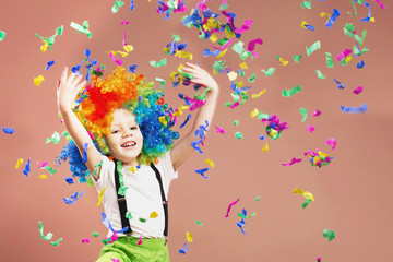 Obraz na płótnie Canvas Little boy in clown wig jumping and having fun celebrating birthday.