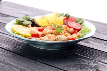 fresh shrimps served on a plate with garlic onion, lemon and chili