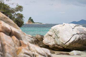 Beautiful beach with big stones and an island on the background
