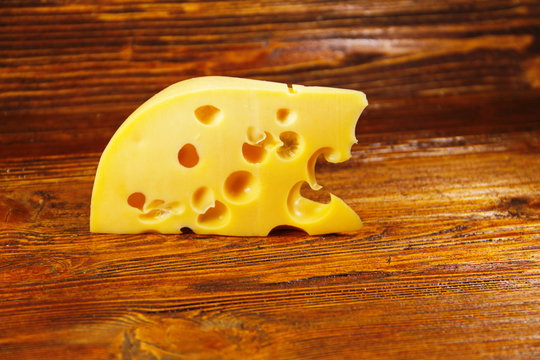 Piece of cheese on the wooden background