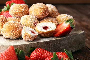 Bomboloni - traditional Italian doughnuts stuffed with strawberry jam