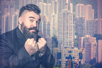 Adult bearded man in a suit showing fists on the background of the cityscape