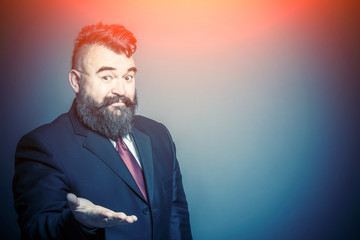 Adult bearded man in a suit with an outstretched hand in the sunlight