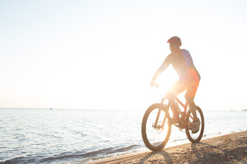 Fototapeta premium Man riding a mountain bike on the beach
