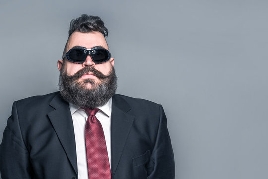 Adult bearded man in a suit and sunglasses