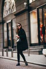 Obraz premium Outdoor fashion portrait of stylish young woman having fun, emotional face , laughing Keeps coffee.