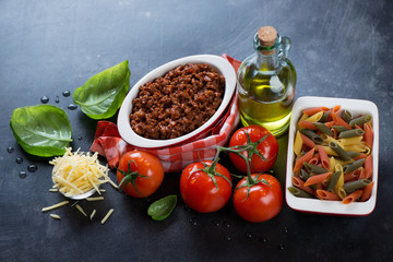 Italian bolognese sauce with penne pasta, tomatoes, green basil and parmesan cheese, studio shot