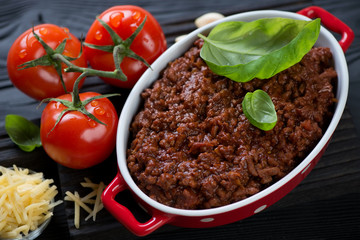 Close-up of freshly made bolognese sauce with green basil, tomatoes and parmesan
