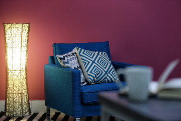 New blue armchair with pillows in modern room