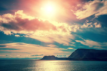 Beautiful blue seascape with dramatic cloudy sky. Wild nature Norway. Island on the horizon. Nordkapp, Mageroya island