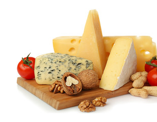 Board with assortment of delicious cheese, tomatoes and nuts on white background