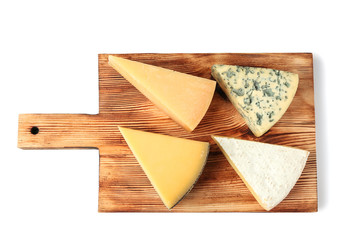 Wooden board with pieces of delicious cheese on white background