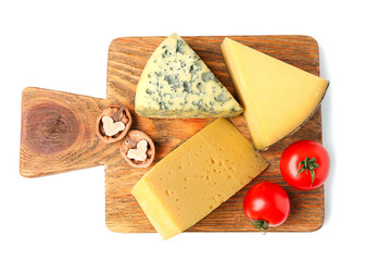 Board with assortment of delicious cheese, tomatoes and nuts on white background