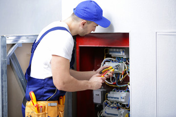 Electrician connecting wires in distribution board