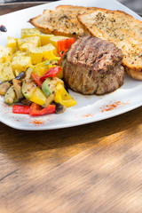 Close up Gourmet Appetizing Roasted Beef Steak with Potato Wedges and Other Vegetables