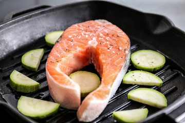 Cooking salmon steak and zucchini on grill pan