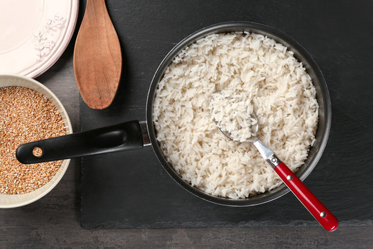 Cooked rice in saucepan with spoon