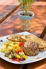Close up Gourmet Appetizing Roasted Beef Steak with Potato Wedges and Other Vegetables