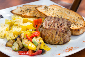 Close up Gourmet Appetizing Roasted Beef Steak with Potato Wedges and Other Vegetables