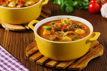 Beef stew served with cooked potatoes.