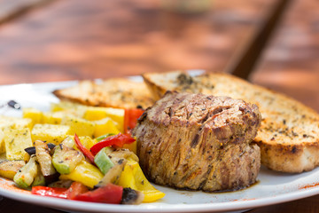 Close up Gourmet Appetizing Roasted Beef Steak with Potato Wedges and Other Vegetables