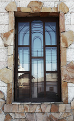 Large window with metal mesh on stone wall background