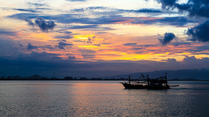Fototapeta na wymiar Silhouette of fishing boats with bursting cloud during Sunrise in background 