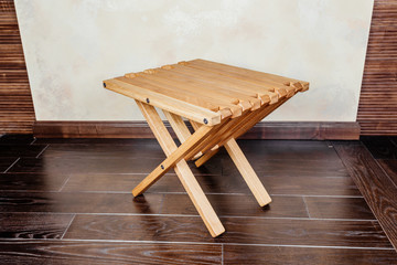 Small wooden folding camp stool, close up. Design / interior redecoration & renovation conceptual