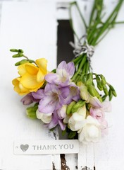 Hand tied posy of spring freesia, shallow depth of field , than you sign 