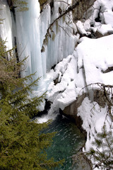 L'acqua scorre tra pareti verticali di ghiaccio e precipita nel piccolo laghetto