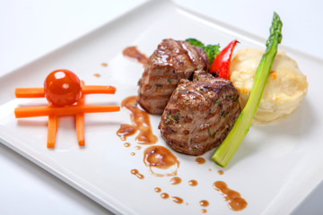 Medallions of grilled veal with potatoes and broccoli.