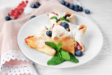 Tasty puff pastry with berries on plate