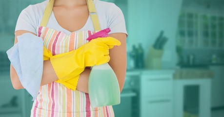 Cleaner standing with spray bottle in kitchen