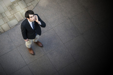 young man looking up and calling with smart phone