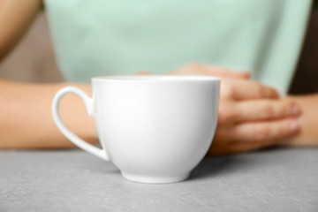 Blank cup and woman on background