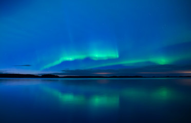 Northern lights dancing over calm lake (Aurora borealis)