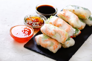 Vietnamese spring rolls - rice paper, lettuce, salad, vermicelli, noodles, shrimps, fish sauce, sweet chili, soy, lemon, veletables. Copy space. Asian and thai food. Traditional national cuisine.