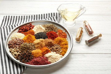 Tray with mix of different spices on wooden table