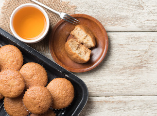banana cup cake in a baking tray and tea on wood,top view