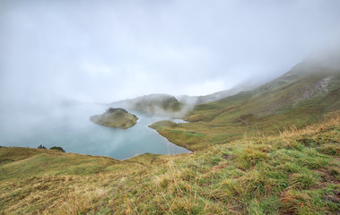 alpine lake in dence fog