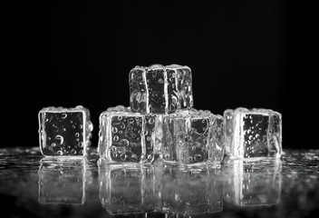 ice cubes on reflection table on black background