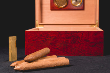 Fototapeta na wymiar Cigar box on black background and lighter