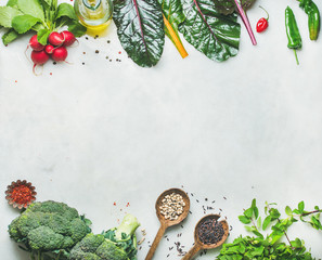 Fresh raw greens, unprocessed vegetables and grains over light grey marble kitchen countertop, top view, copy space. Clean eating, healthy, vegan, vegetarian, detox, dieting food concept