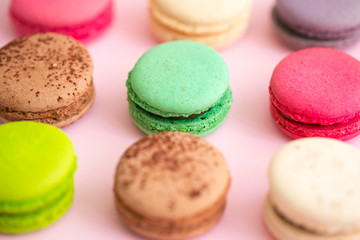 Multicolored macaroon cookies on a pink background