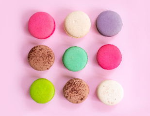Multicolored macaroon cookies on a pink background