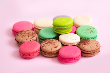 Fototapeta na wymiar Multicolored macaroon cookies on a pink background