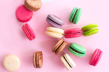 Multicolored macaroon cookies on a pink background