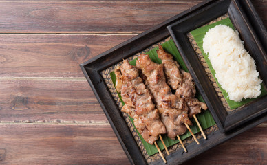 Thai styled grilled pork and sticky rice on wood